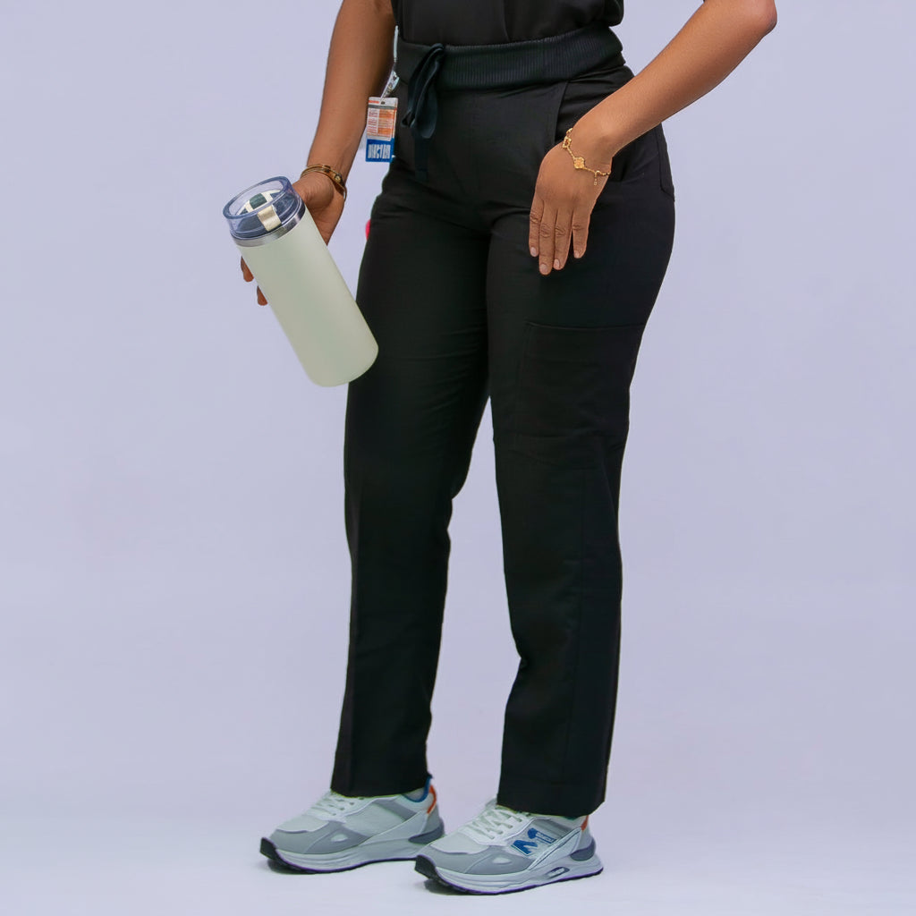 Person wearing a black medical uniform with a stethoscope, holding a water bottle on a light gray background