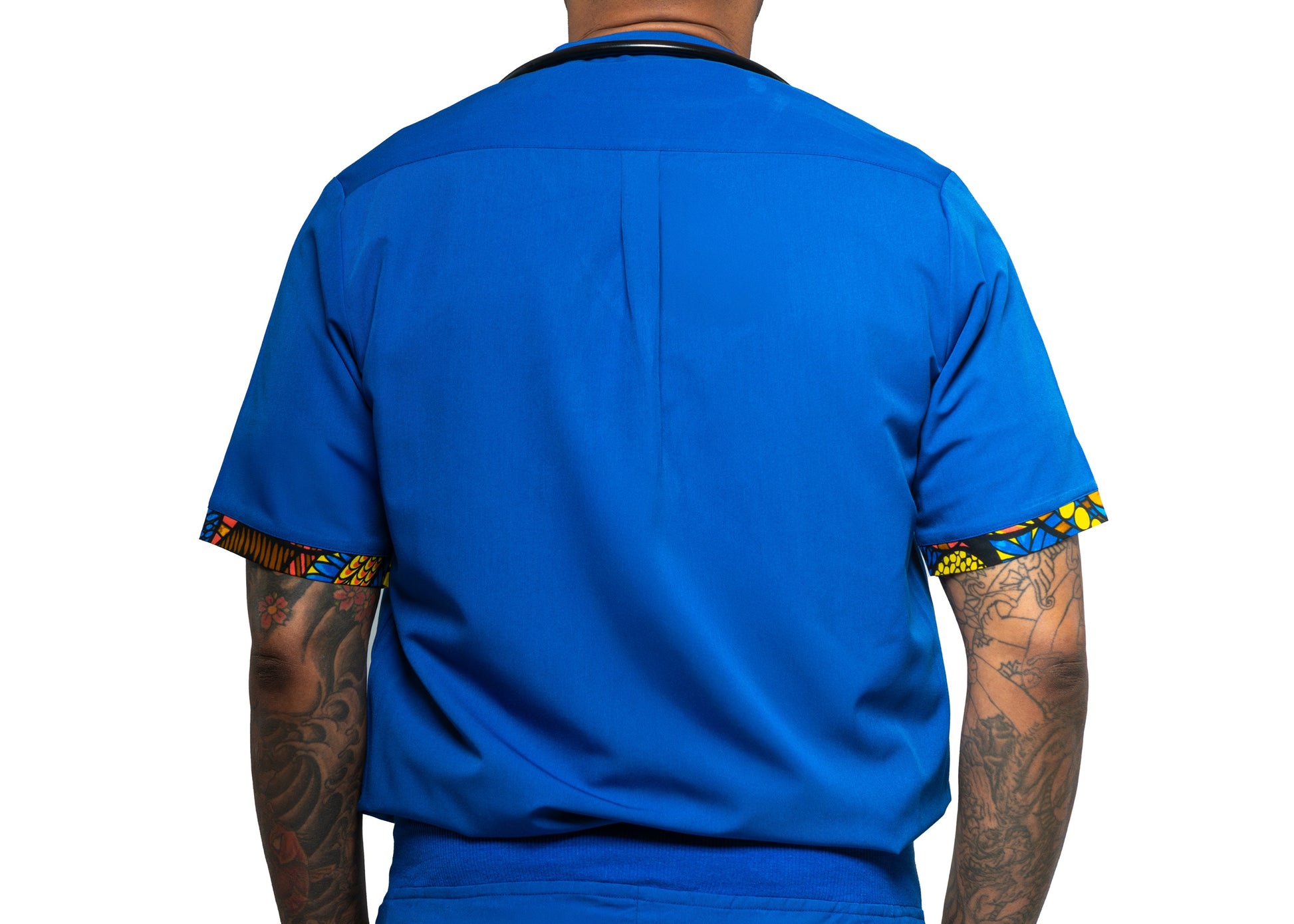 A man wearing a blue male scrub top with a V-neck and a single chest pocket, with a stethoscope around his neck.