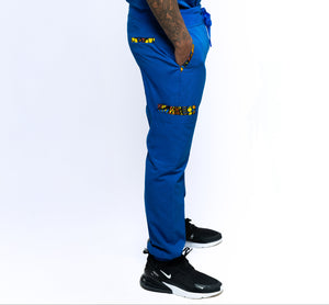 A person wearing blue Dara scrub jogger pants with a drawstring waist and pockets, paired with a blue top and black shoes.