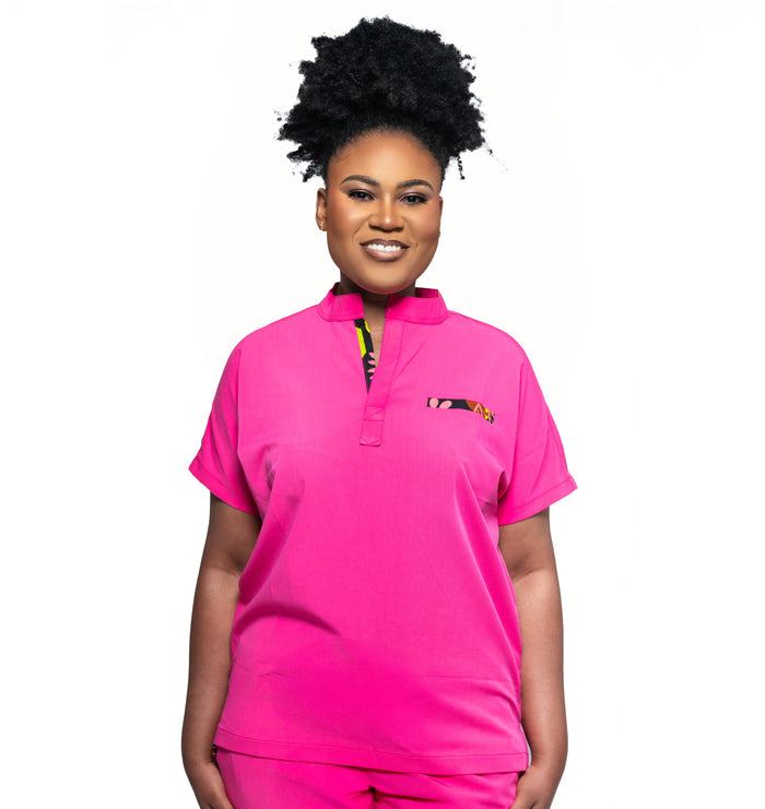A woman wearing a pink Makeda scrub top with a mandarin collar.