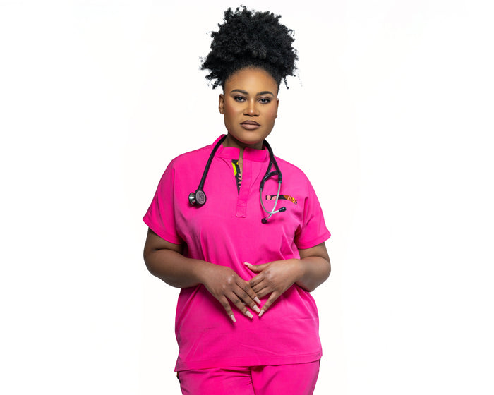 A woman wearing a pink Makeda scrub top with a mandarin collar.