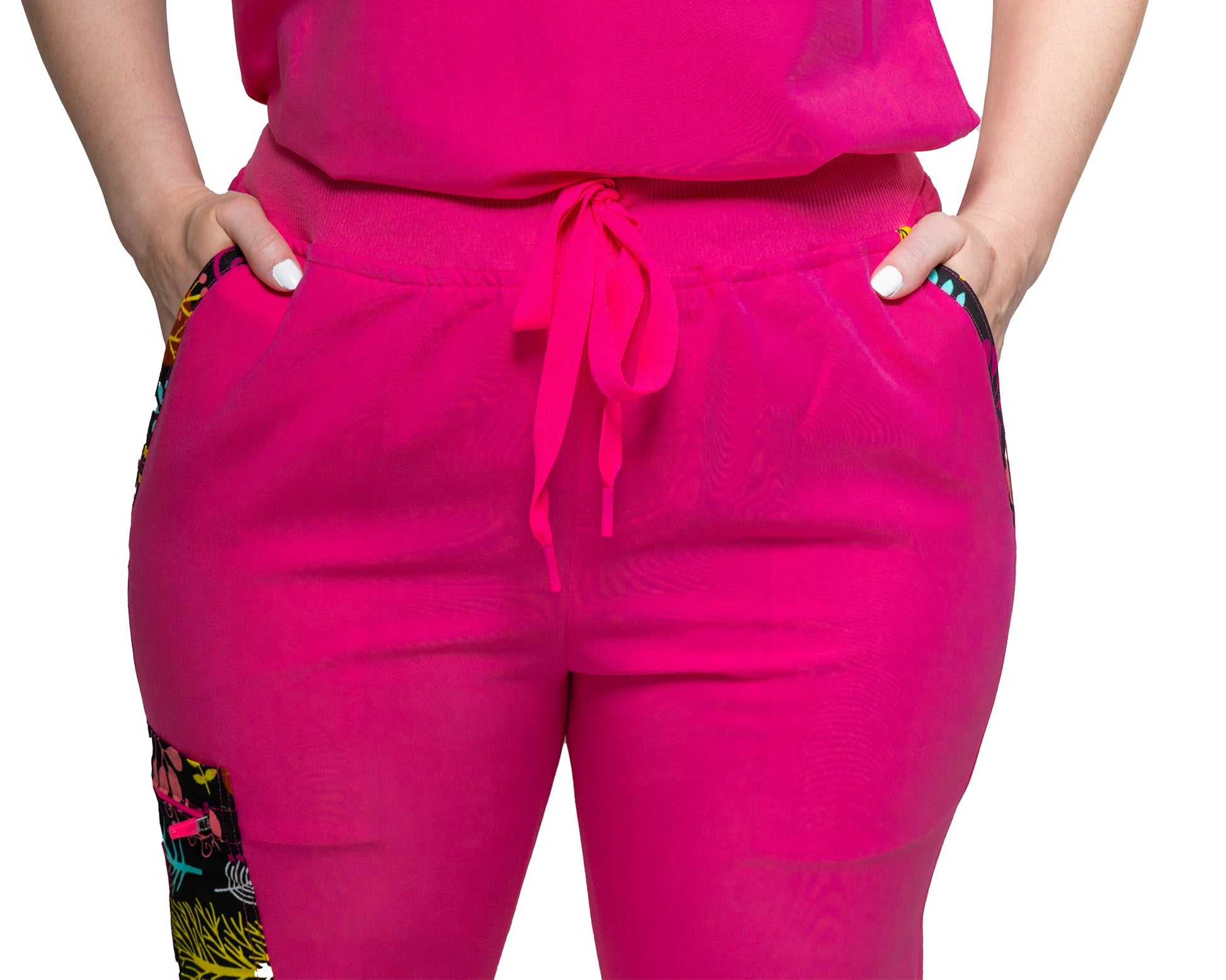 A person wearing pink female Nia Scrub Pant with decorative detail on the knee area.