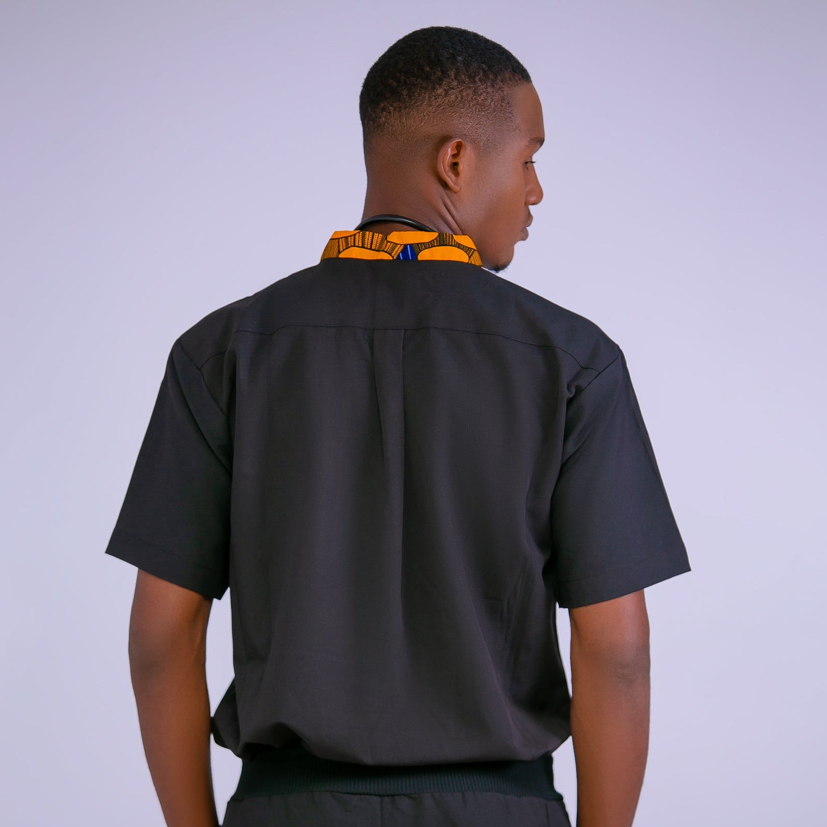 Person wearing a black shirt and pants on a light purple background