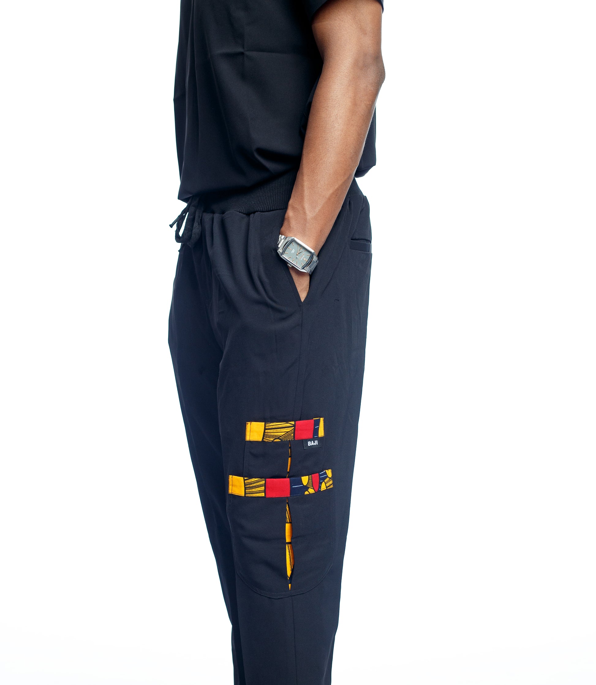 Black scrub pants with colorful geometric design on a white background