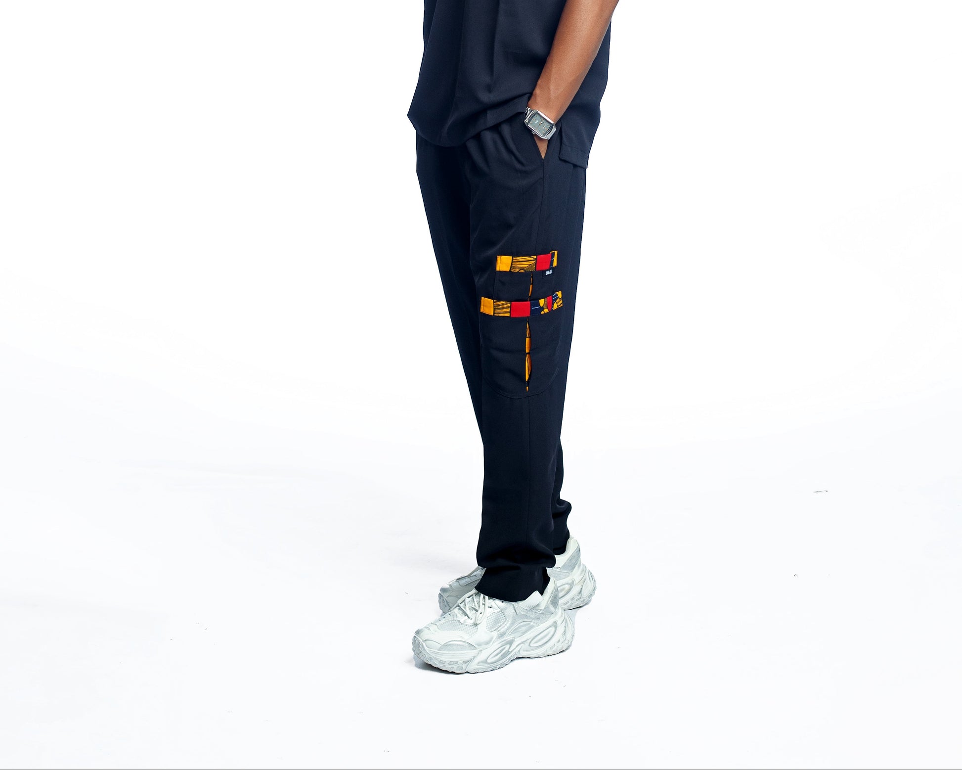 Person wearing a black scrub pant with a white background