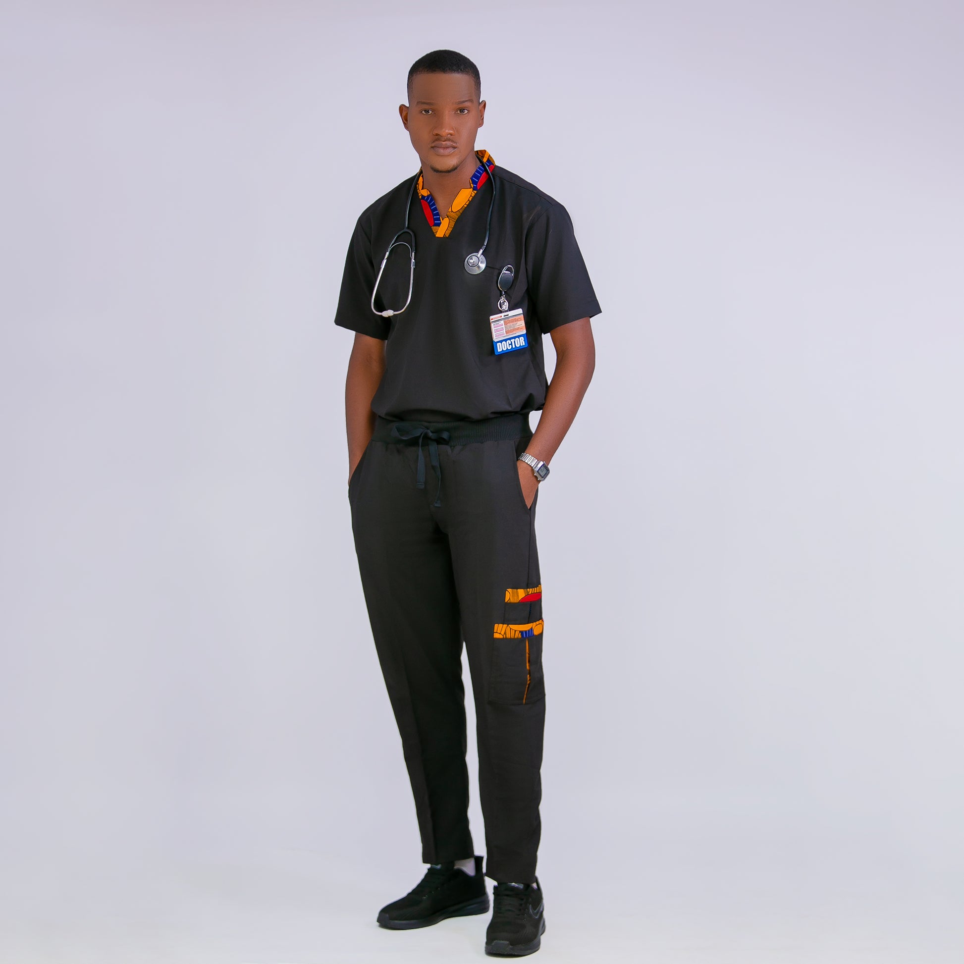 Person wearing a black medical scrub set with a stethoscope on a white background