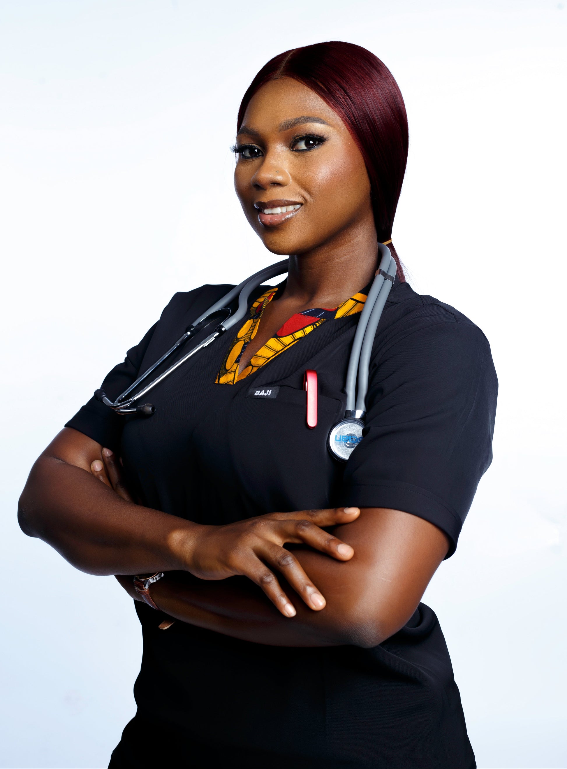 Female in black scrubs with arms crossed on a white background