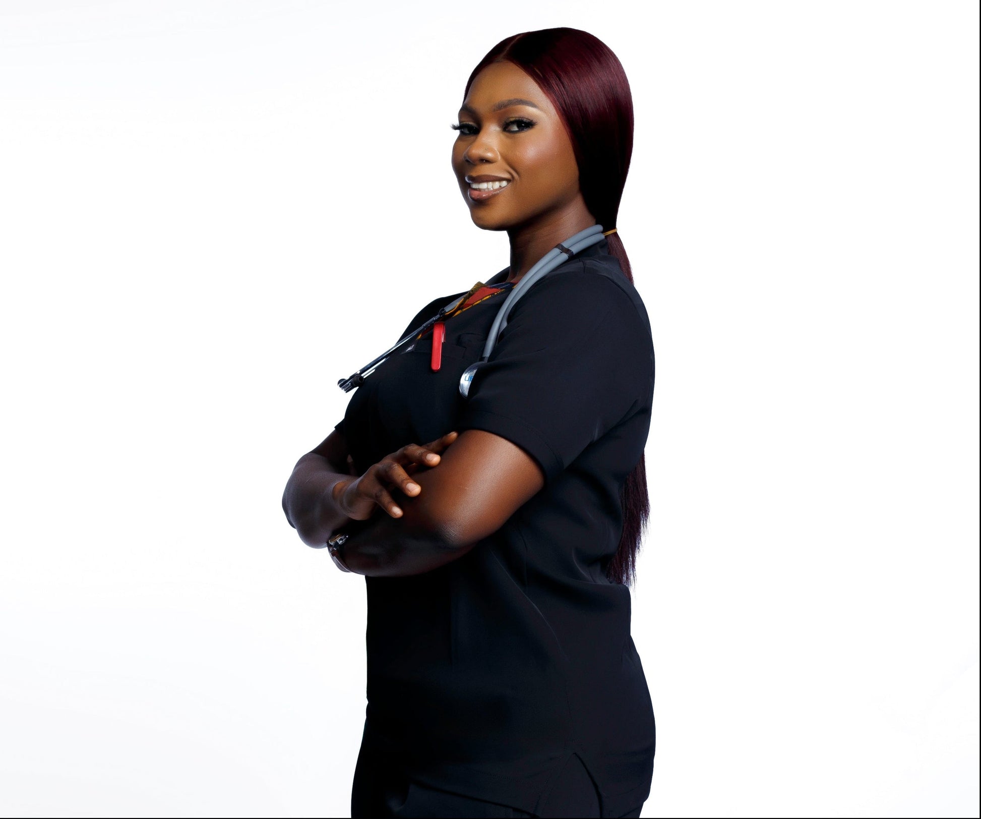 Person wearing a black scrub outfit with colorful accents on a white background